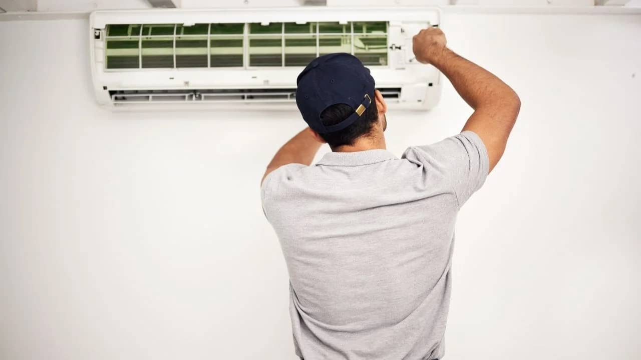 HVAC technician servicing AC unit at Manotick heritage home